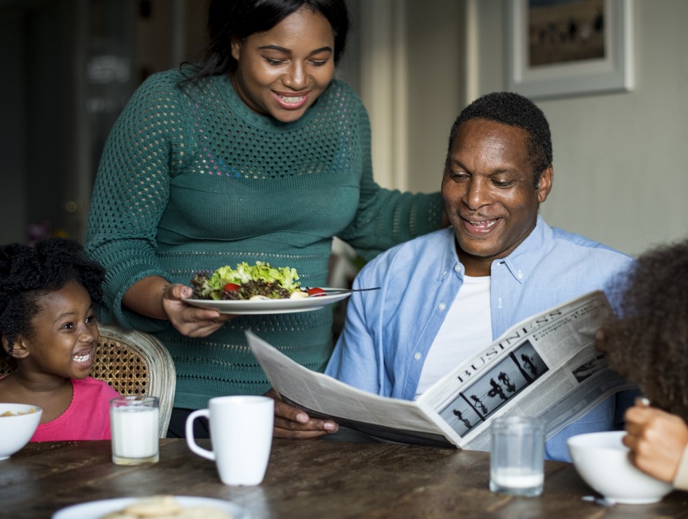 丈夫看报纸时，女人给他端上沙拉。