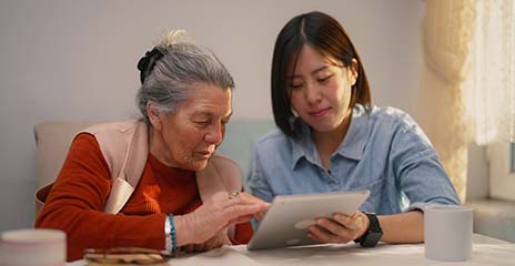 正在看平板电脑的年长女性和年轻人