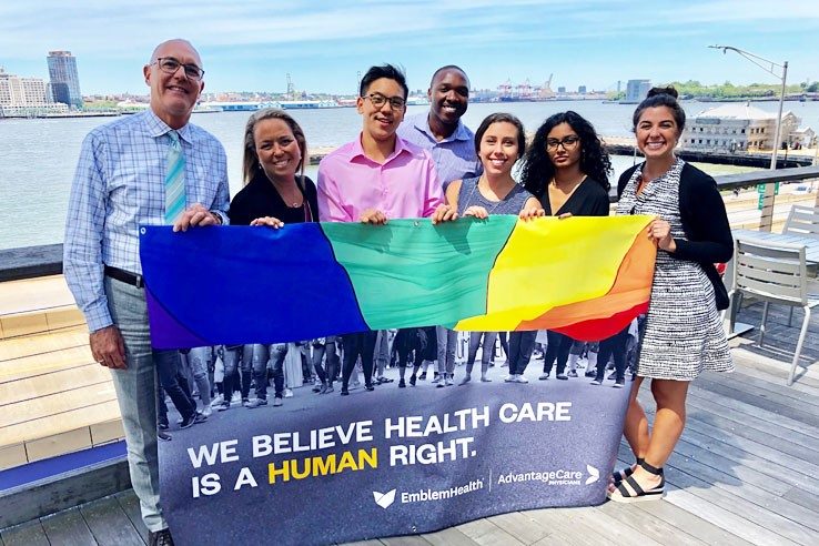 Prism 的领导人员和合作伙伴在 Water Street 展示我们 2019 年的骄傲旗帜