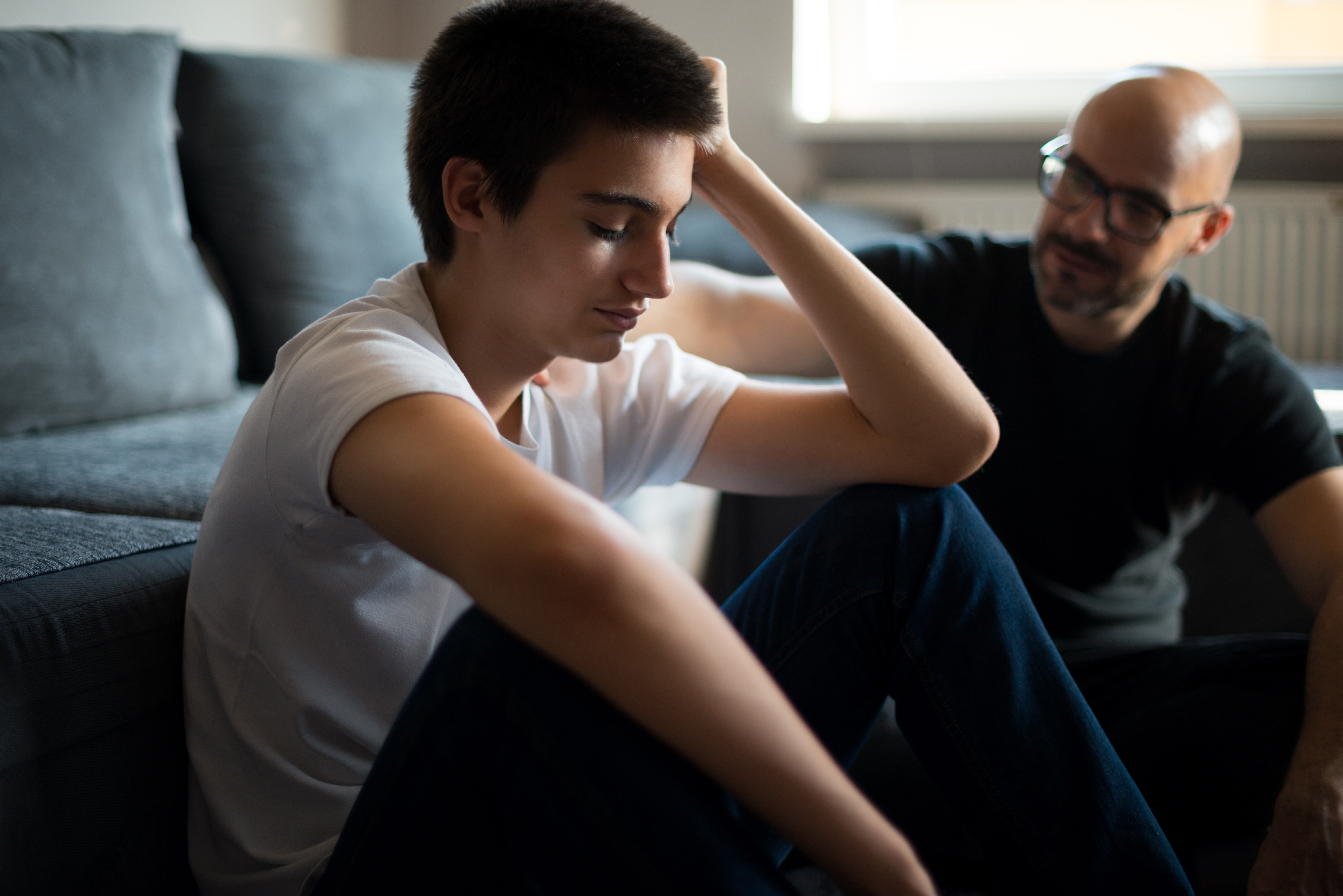 心烦意乱的年轻人和他的父亲谈话。