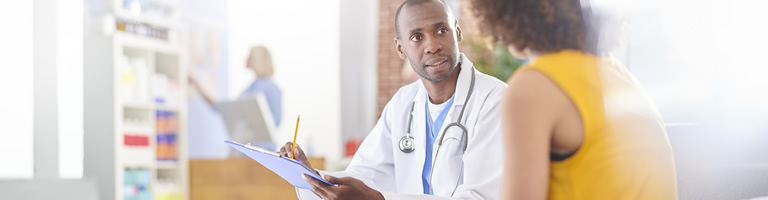 doctor discussing medication with female customer with checkout counter in the background