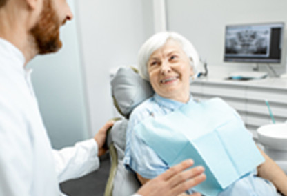 老年女性坐在牙医病人的椅子上微笑